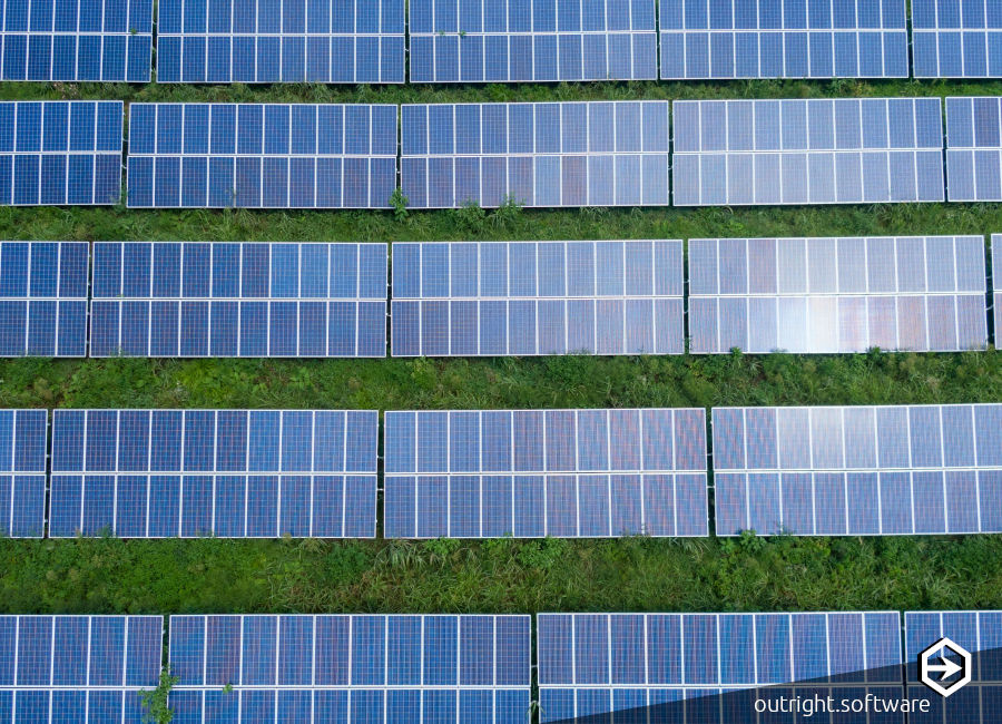 6 rows of blue solar panels in a green field.