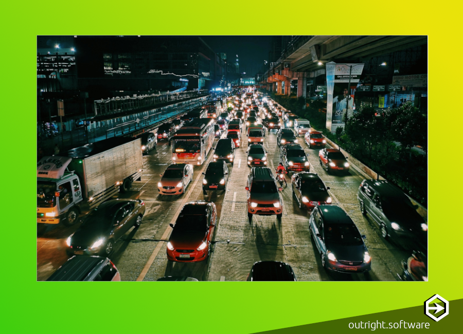 A nighttime photograph of a highway with cars stretching off into the horizon in heavy traffic.